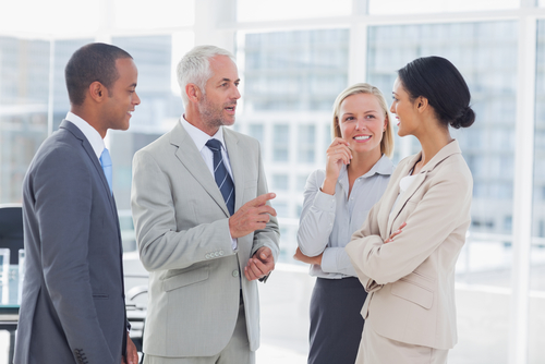 four people in suits talking