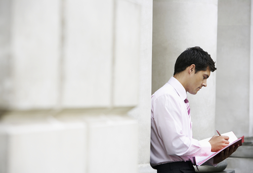 Banker outside bank looking at documents